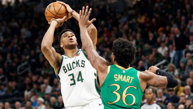 Giannis Antetokounmpo shoots the ball over Marcus Smart